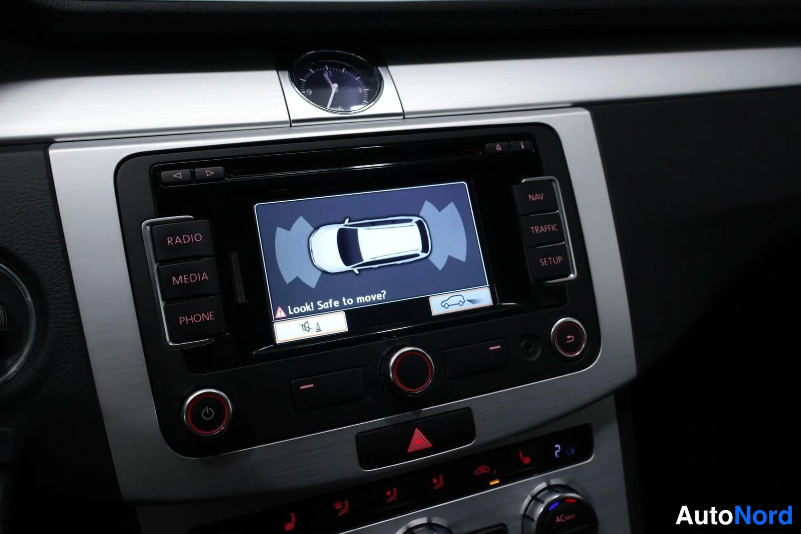 Muu: Keskikonsolin radio-näyttö näyttää pysäköintianturien grafiikan auton ympärillä ja tekstin 'Look! Safe to move?'. Napit RADIO, MEDIA, PHONE, NAV, TRAFFIC, SETUP