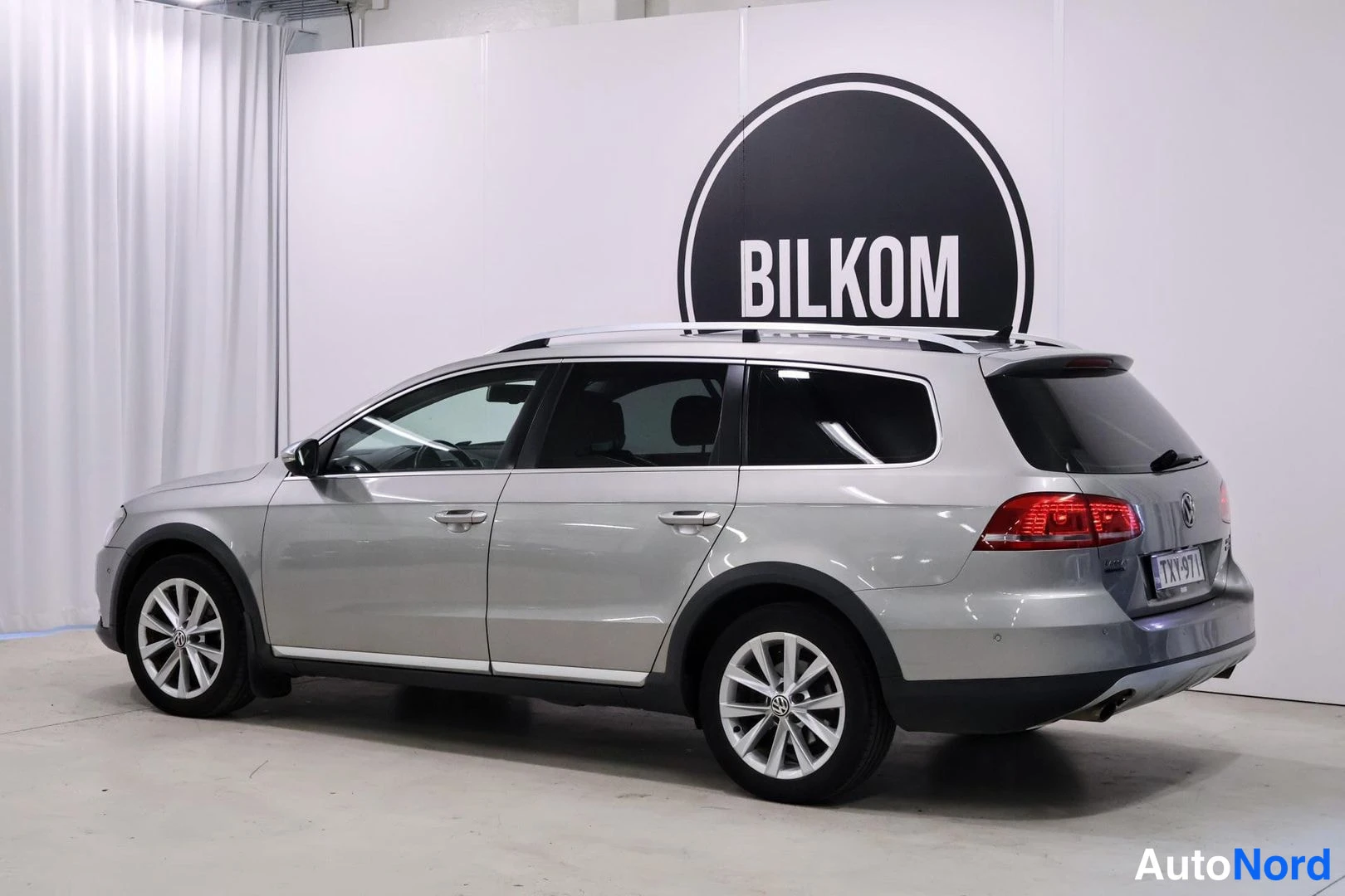 Takaviisto: Hopeanharmaan Volkswagen Passat Variantin takaviisto vasemmalta kuvattuna, perä ja kylki näkyvissä.