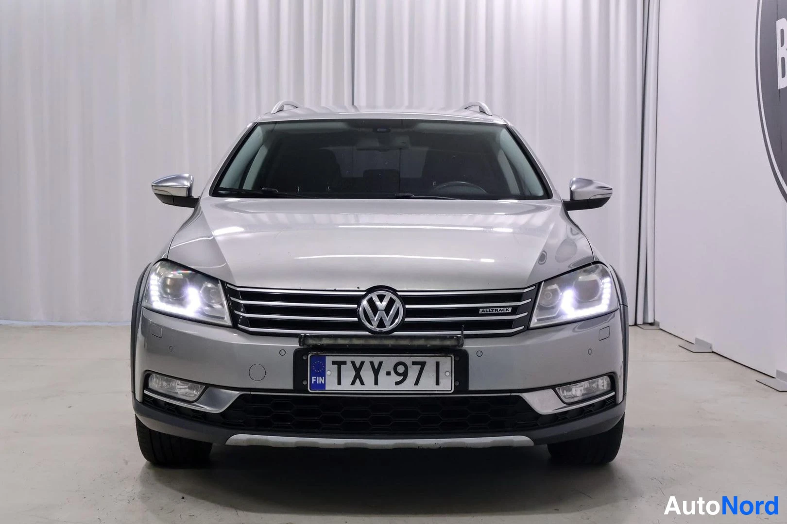 Edestä: Volkswagen Passat -farmari suoraan edestä, hopeinen koriväri.