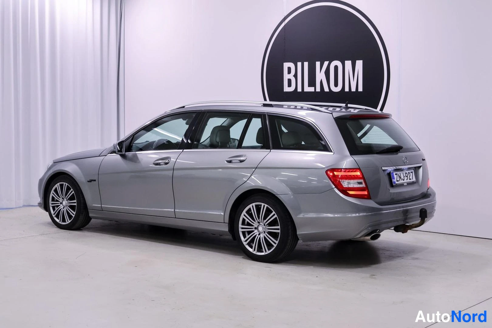 Takaviisto: Mercedes-Benz C -farmari takanurkkikuva oikealta, hopeanharmaa kori, rekisteritunnus.