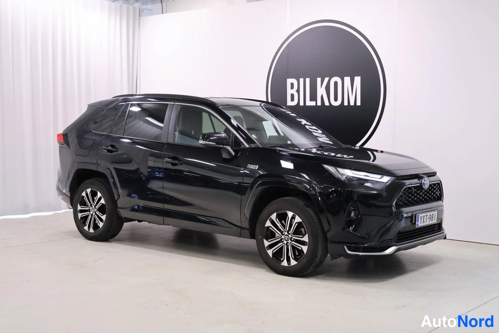 Etuviisto, nokka oikealle: Musta Toyota RAV4 -maasturi kulmasta edestä oikealta valkoisessa studiossa, kylki ja keulanosa näkyvissä.