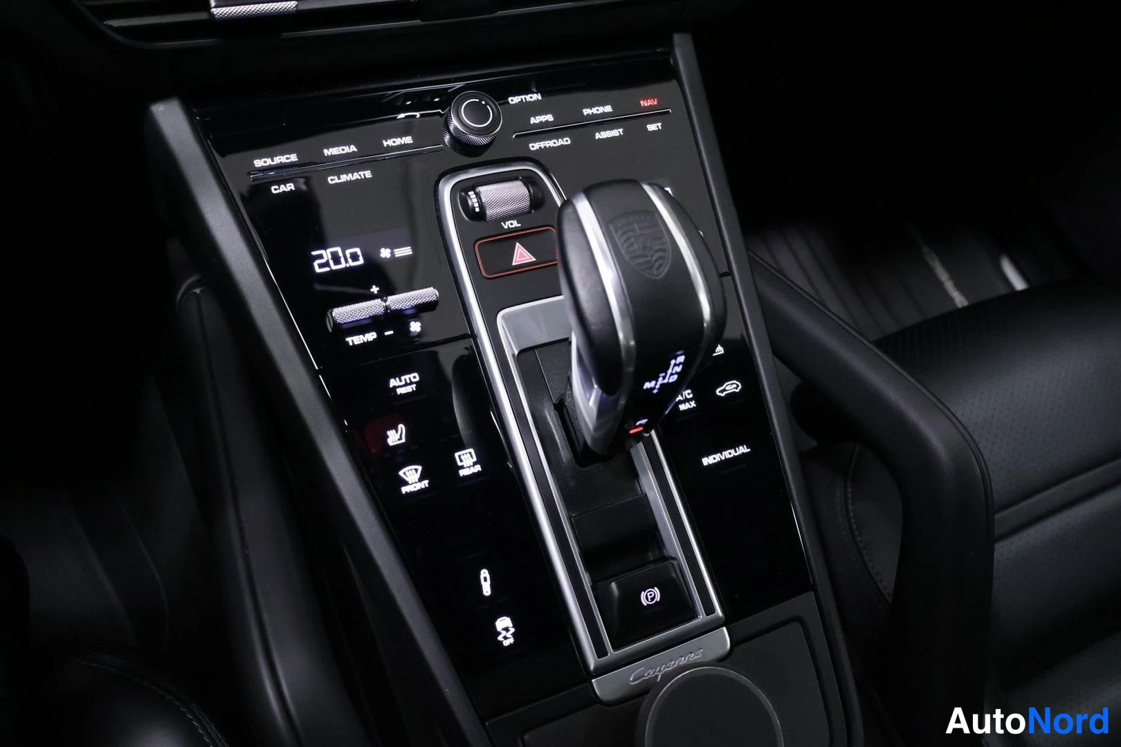 Ohjaamo: Center console featuring the automatic gear selector, illuminated touch control panel for climate settings displaying '20.0', heated seat switches, and the cent