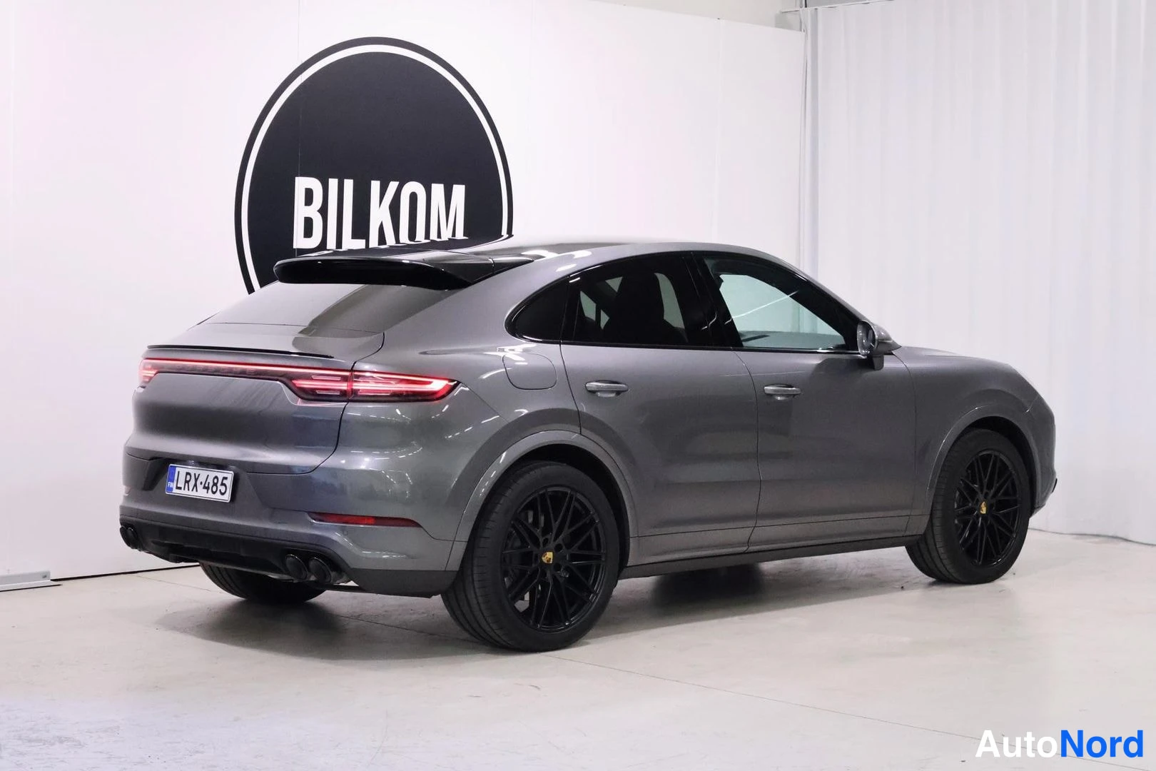 Takaviisto: Porsche Cayenne Coupé takaviisto sivusuunnasta, harmaa koriväri, mustat kevytmetallivanteet, rekisteri.