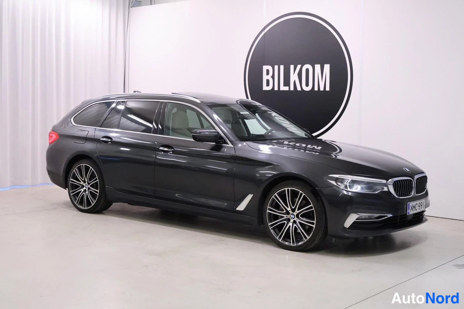 Etuviisto, nokka oikealle: BMW 5-sarjan farmariauto kolmanneltä osakulmalta, keula oikealla.