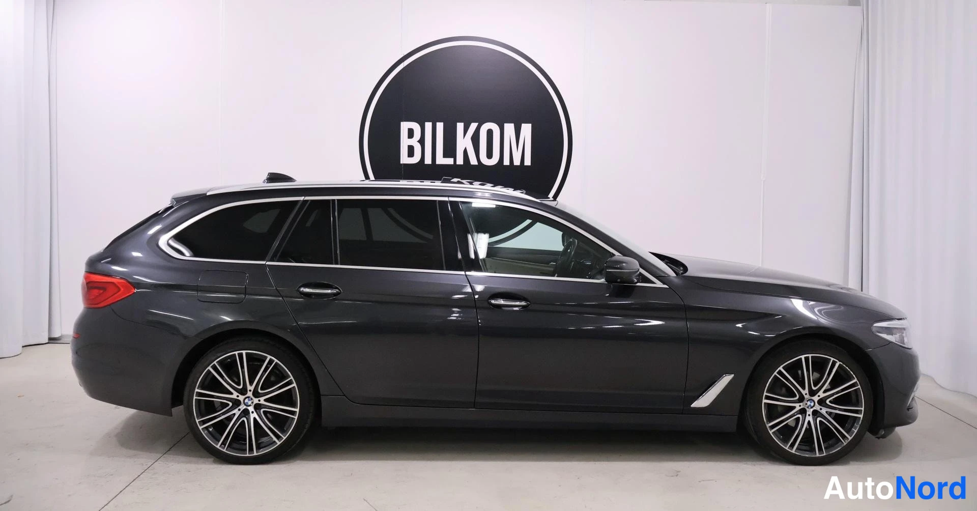 Sivulta: BMW 5-sarjan farmarin sivuprofiili, auton molemmat sivut osittain näkyvissä.