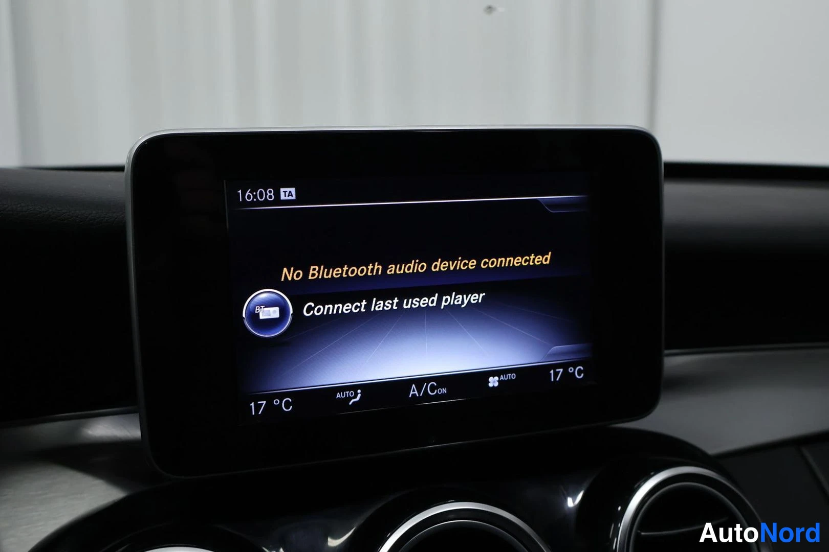 Yksityiskohta: Auton kojelaudan infotainment-näyttö, jossa teksti 'No Bluetooth audio device connected' ja 'Connect last used player'; näytön alareunassa lämpötilat 17 °C mole