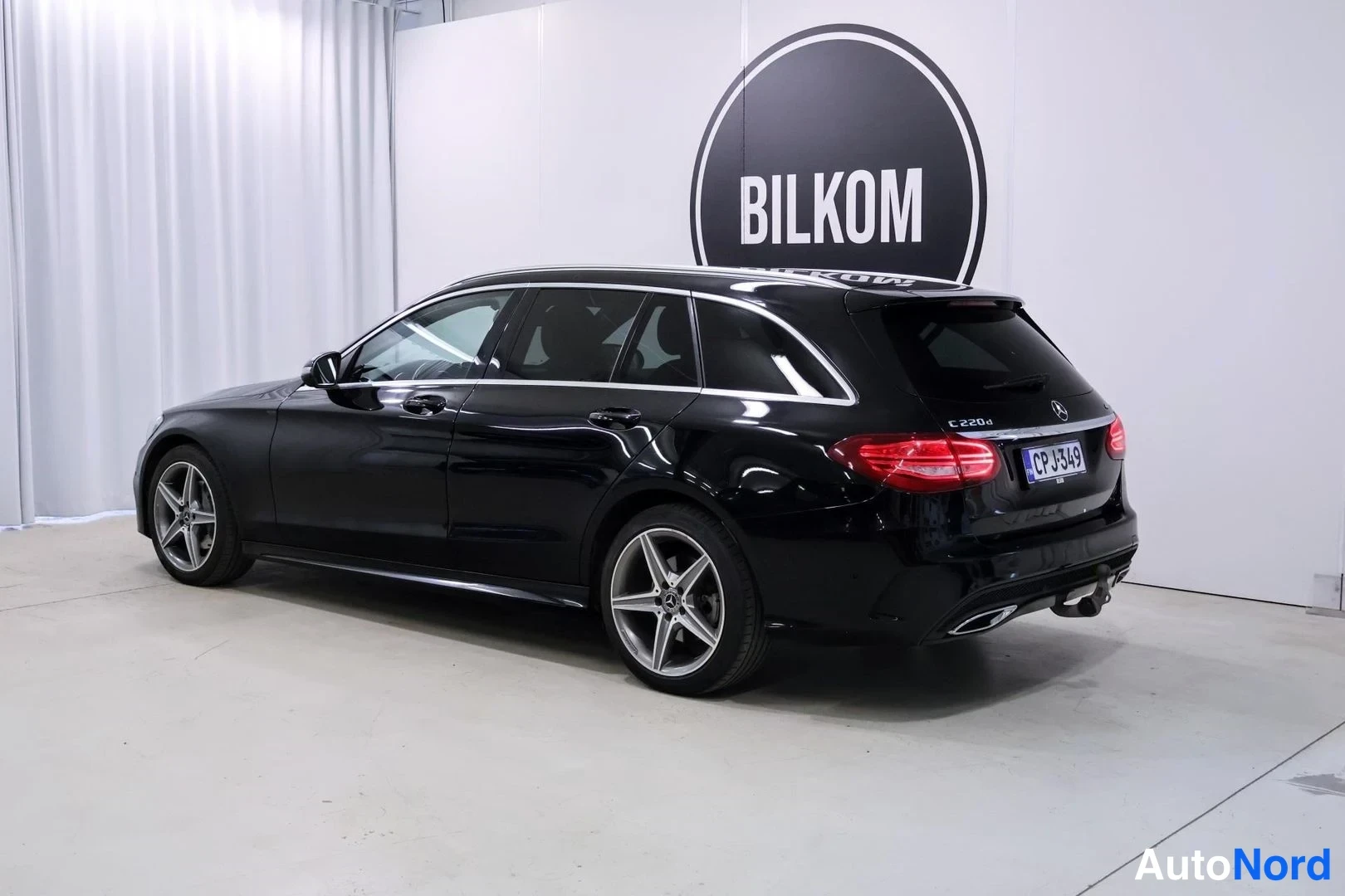 Takaviisto: Musta Mercedes-Benz C 220d farmari takaviistosta kuvattuna studioympäristössä.