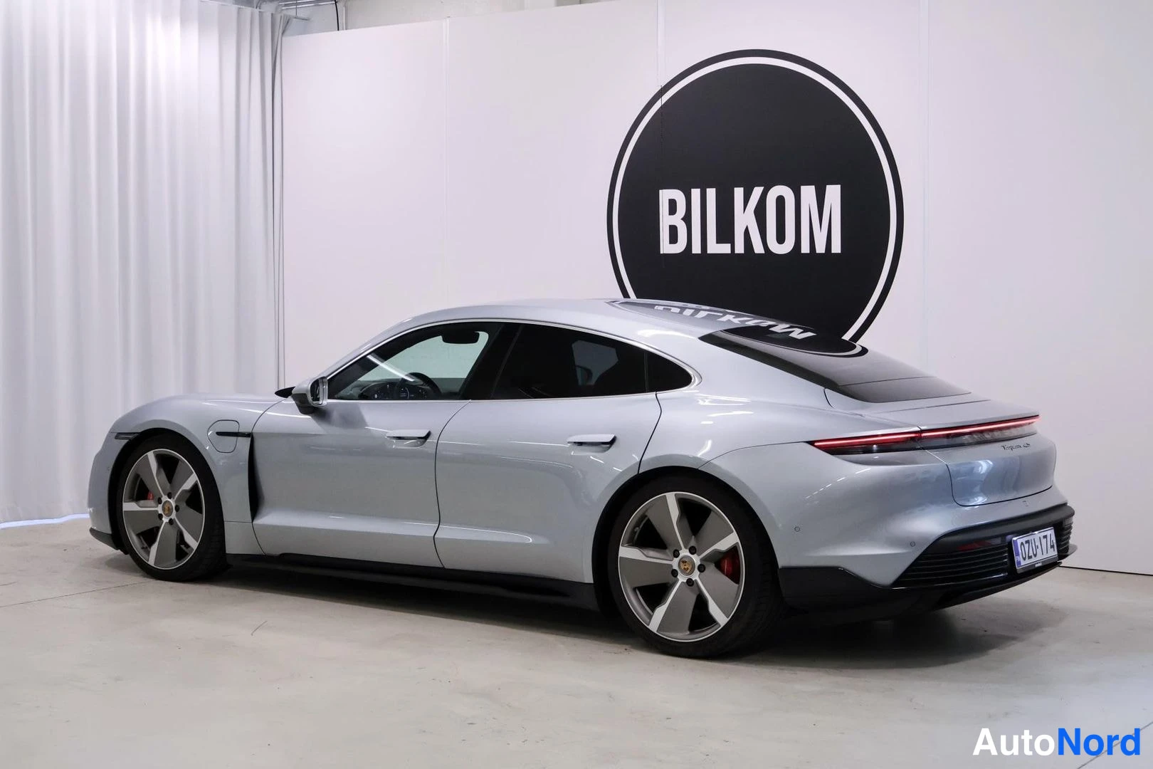 Takaviisto: Porsche Taycan 4S, hopea sedan takakulmasta oikealta, punainen takavalokampa näkyvissä.