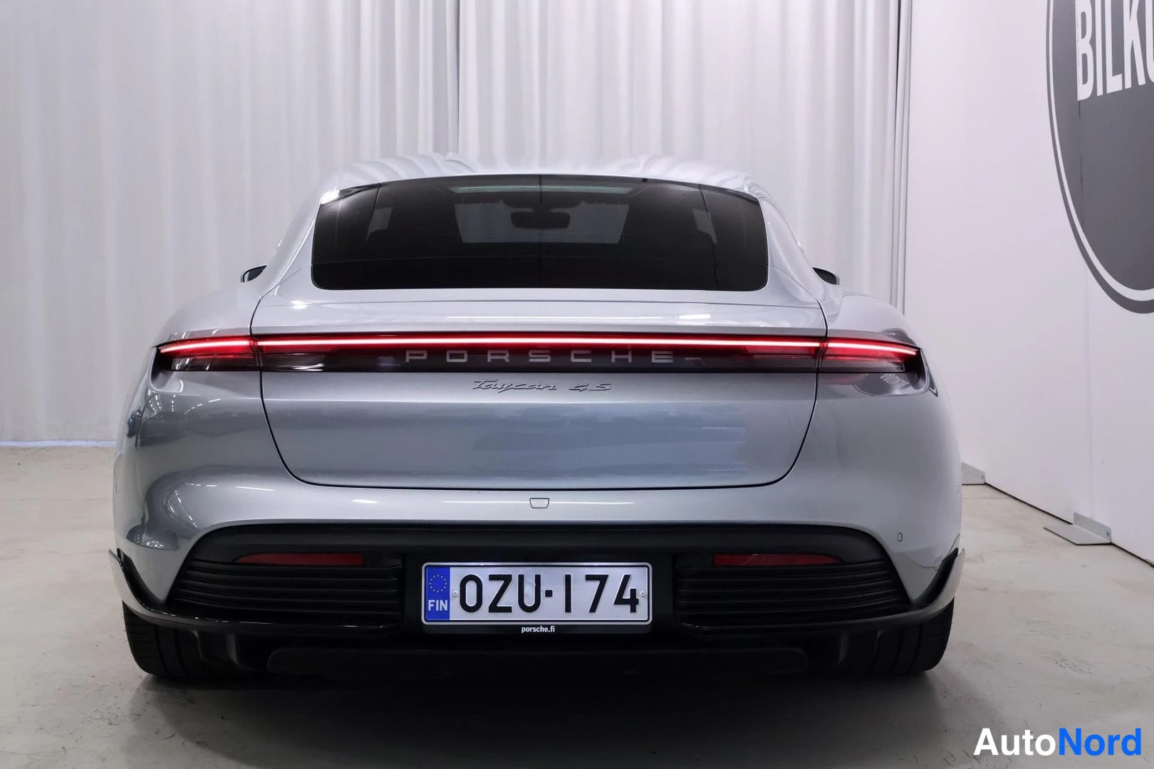 Takaa: Porsche Taycan 4S suoraan takaa, konepellissä teksti Porsche Taycan 4S, rekisteritunnus.