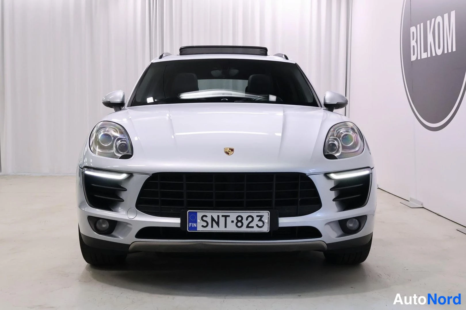 Edestä: Hopeanvärinen Porsche Macan suoraan edestä, rekisteritunnus.