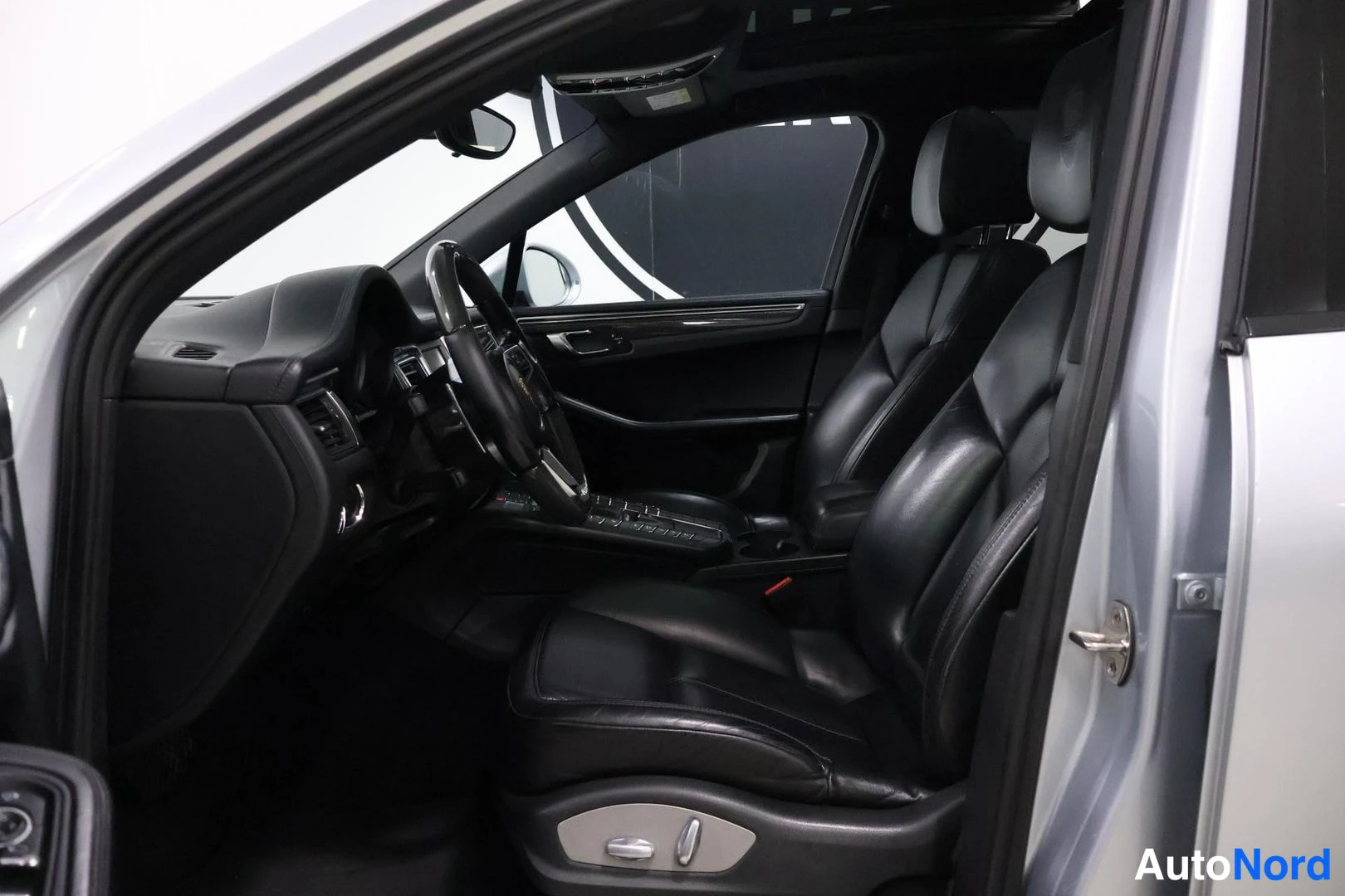 Etuistuimet: Valkoinen Porsche-mallin etuistuimin näkyvissä, joissa sähköiset säätöpainikkeet alaosassa