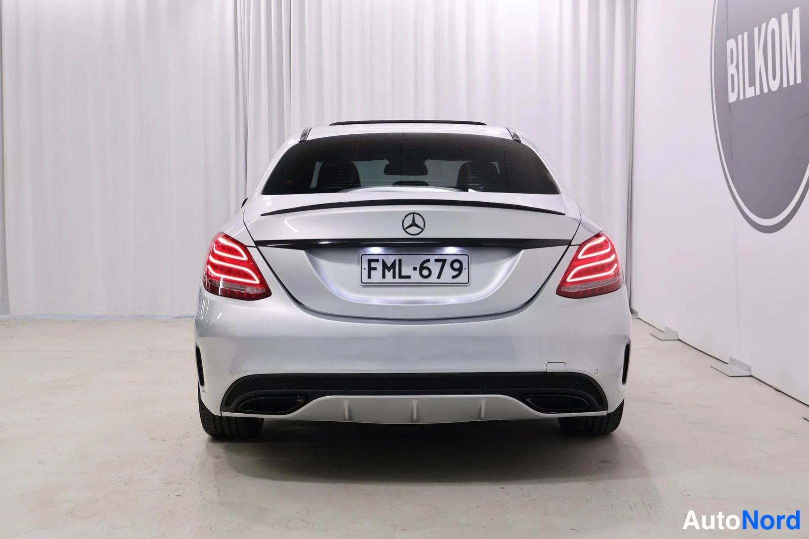 Takaa: Rear view photograph of silver Mercedes-Benz C-Class displaying complete tail lamp assembly on both sides, trunk lid badge (three-pointed star), registration pl