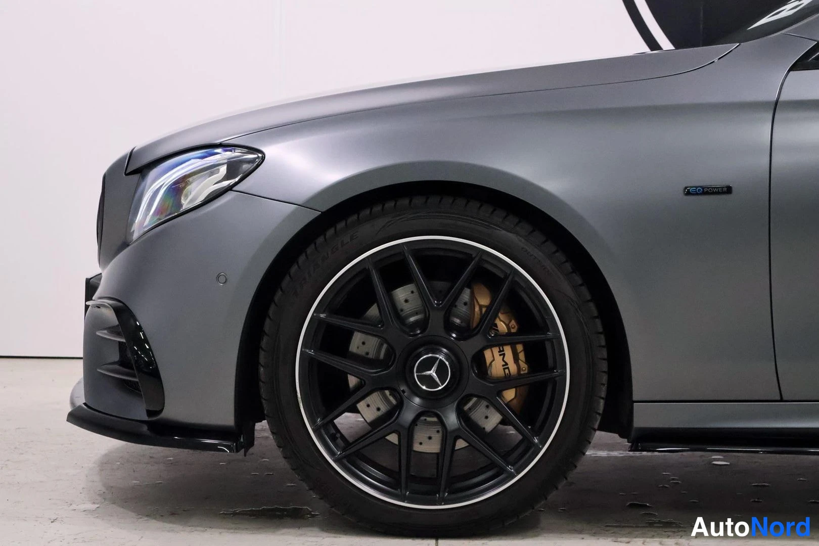 Yksityiskohta: Lähikuva auton oikeasta edesta pyörästään, jossa on mustat spottipyörät, joiden keskellä on Mercedes-logo ja joissa keltaiset jarrukiekot. Oikealla puolella on