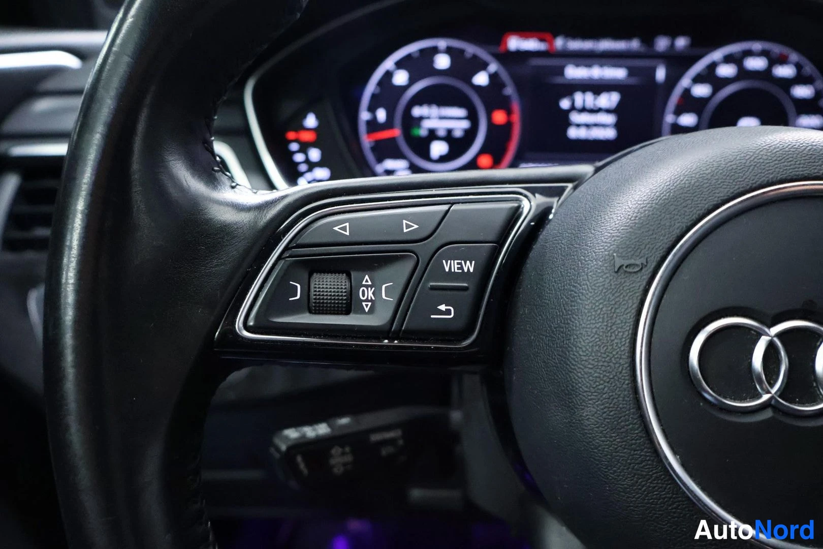Muu: Lähikuva Audi A4:n ohjauspyörän vasemmasta nipasta, josta hallitaan kojelaudan näyttöä (VIEW- ja OK-painikkeet).