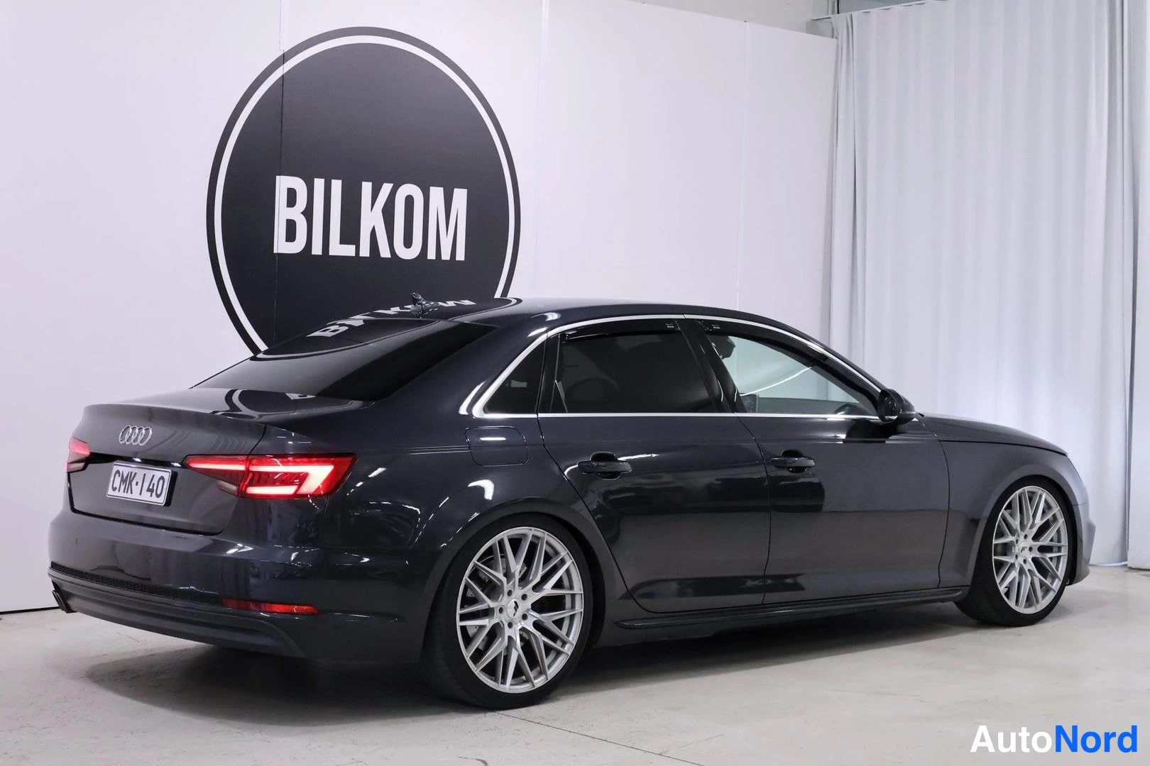 Takaviisto: Musta Audi A4 sedanin takasivu kolmannelta kuvattuna studiossa, jossa on hopeiset vanteet.