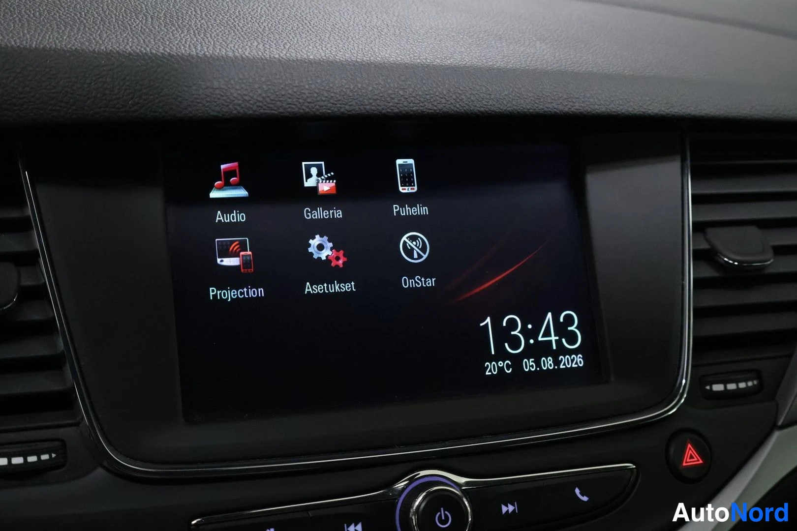 Muu: Close-up of the vehicle's central infotainment touchscreen display showing app icons including Audio, Gallery, Phone, Projection, Settings, and OnStar. The scre