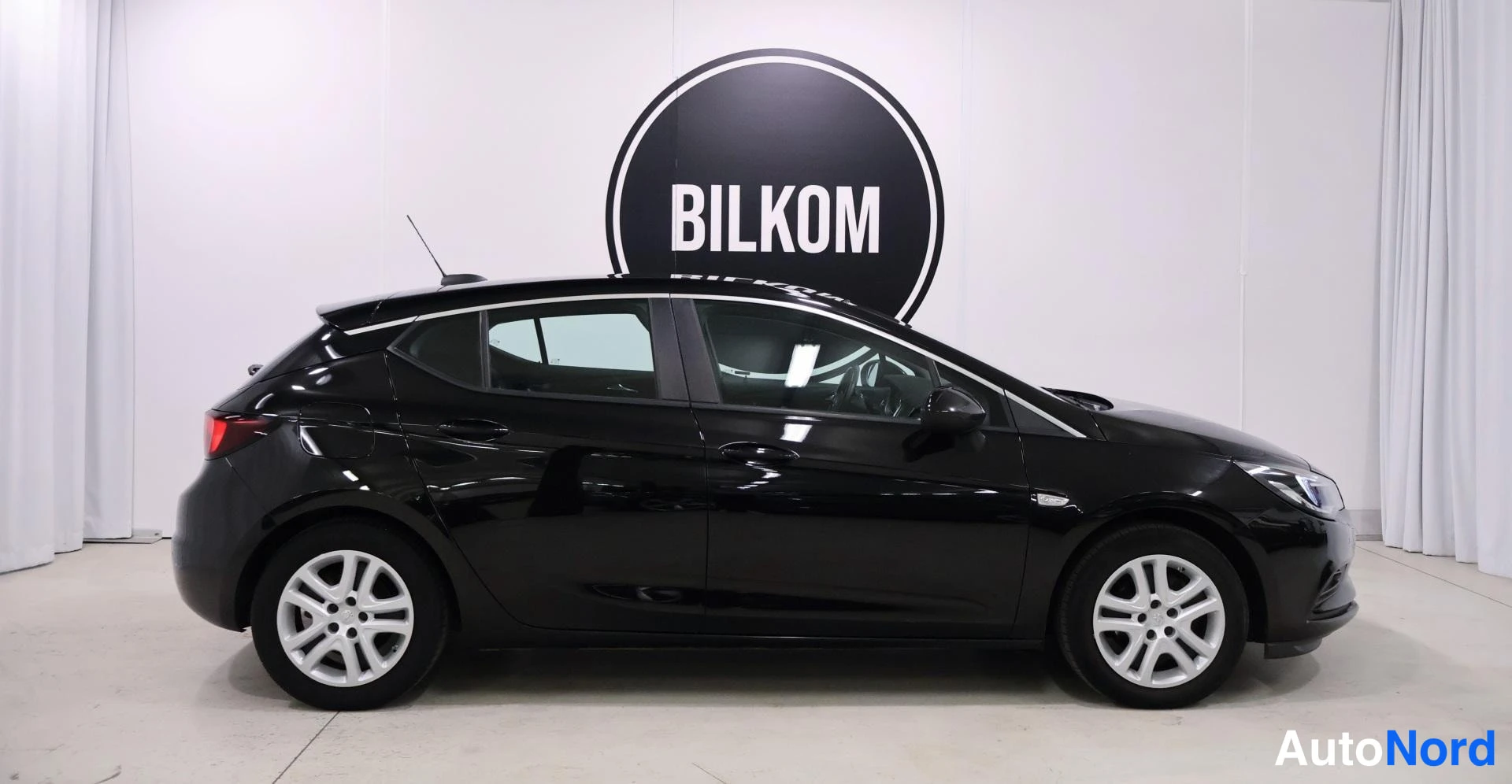 Sivulta: Mustan Opel Astra -farmarin sivukuva vasemmalta sisätiloissa.