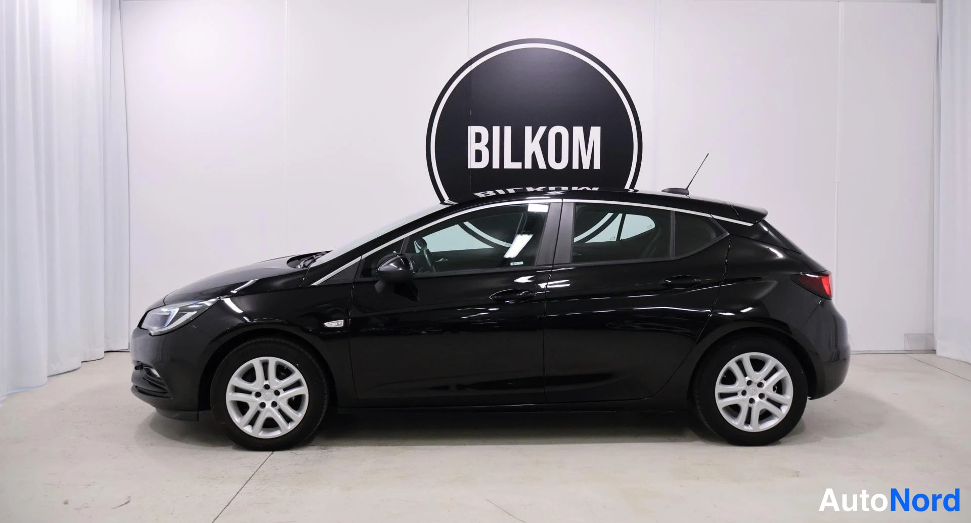 Sivulta: Mustan Opel Astra -farmarin sivukuva oikealta sisätiloissa.