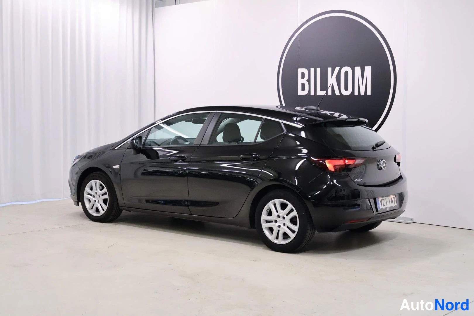Takaviisto: Mustan Opel Astra -farmarin takakulma oikealta, rekisteri.