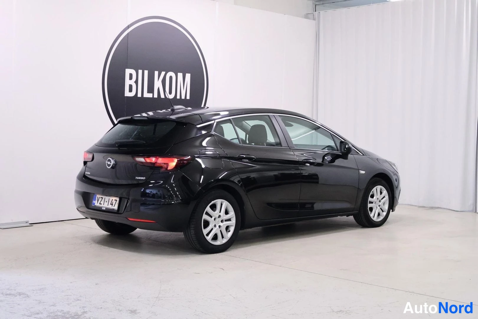Takaviisto: Black Opel Astra five-door hatchback photographed at a rear three-quarter angle showing both side flank and tail end, featuring alloy wheels, rear wiper, and re