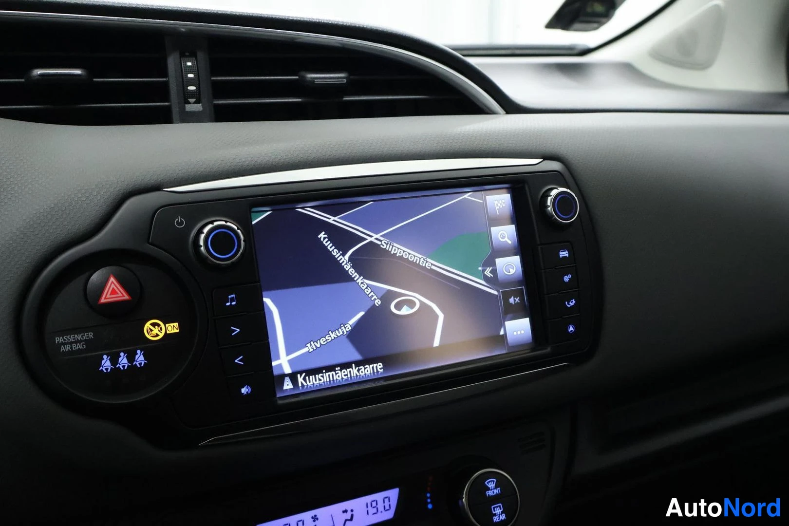 Ohjaamo: Center console infotainment touchscreen displaying a navigation map. Screen shows street names including 'Kuusimäenkaarre' and 'Siippoontie'. Physical control k