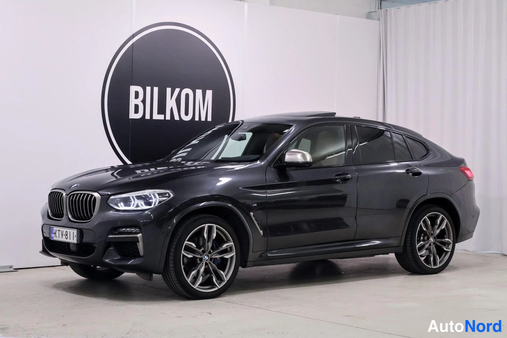 Etuviisto, nokka vasemmalle: BMW X4 etukulmakuva sisätilassa, kylki ja etuosa näkyvissä.