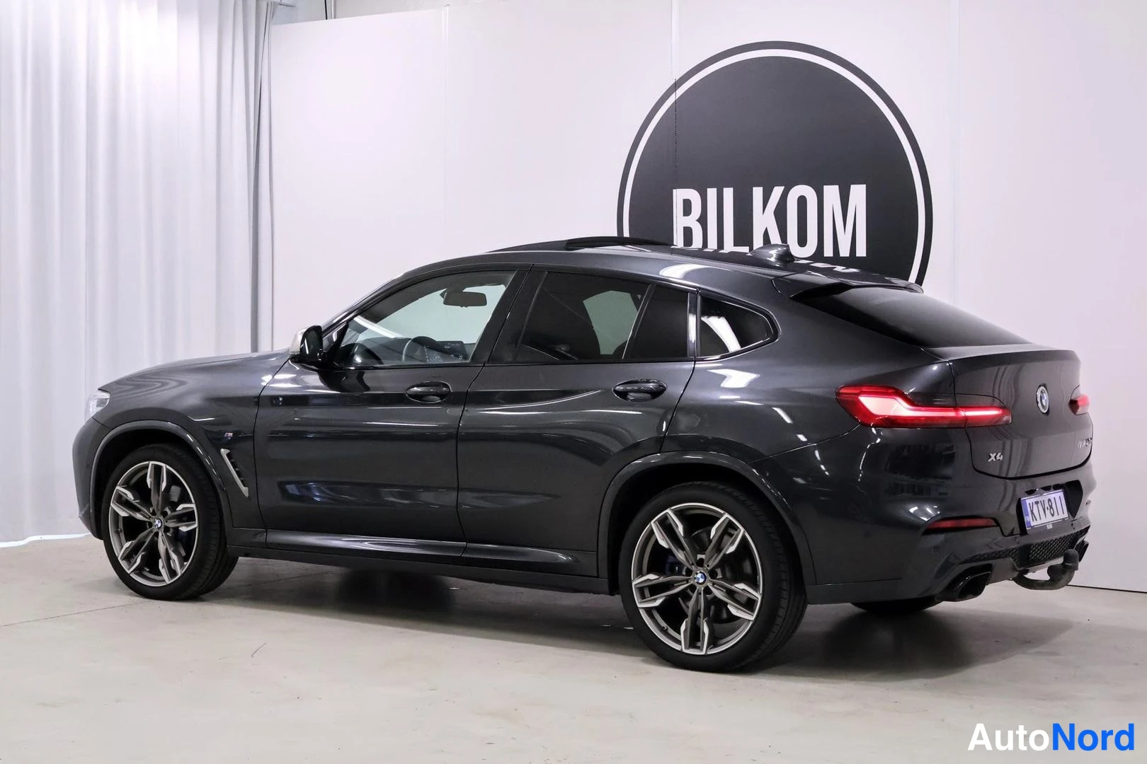 Takaviisto: BMW X4 tikkujen takakulmakuva sisätilassa, perä ja kylki näkyvissä.