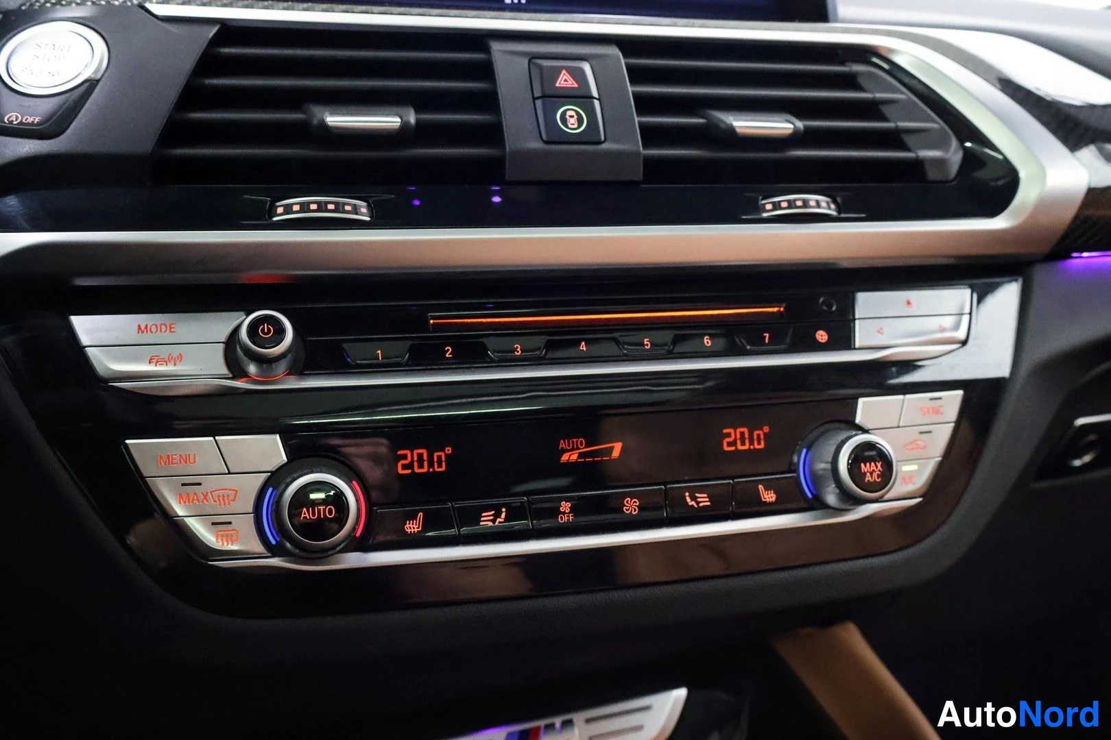 Muu: Läheiskuva kojelaudan ilmastointipaneelista, jossa näkyy kaksialueinen automaattimilastointi (AUTO, molemmat lämpötilat 20.0°), kierrätyneitä ilmanvaihtoaukkoja