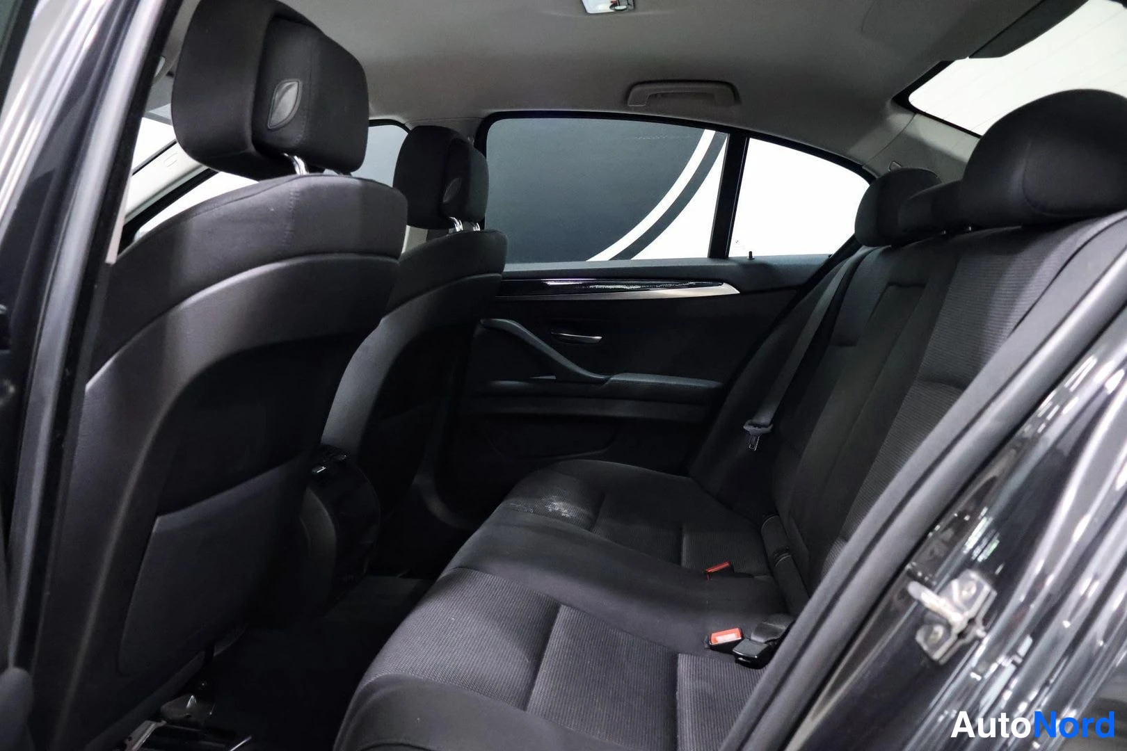 Takaistuimet: Rear bench seat with three headrests; interior shows rear seating capacity