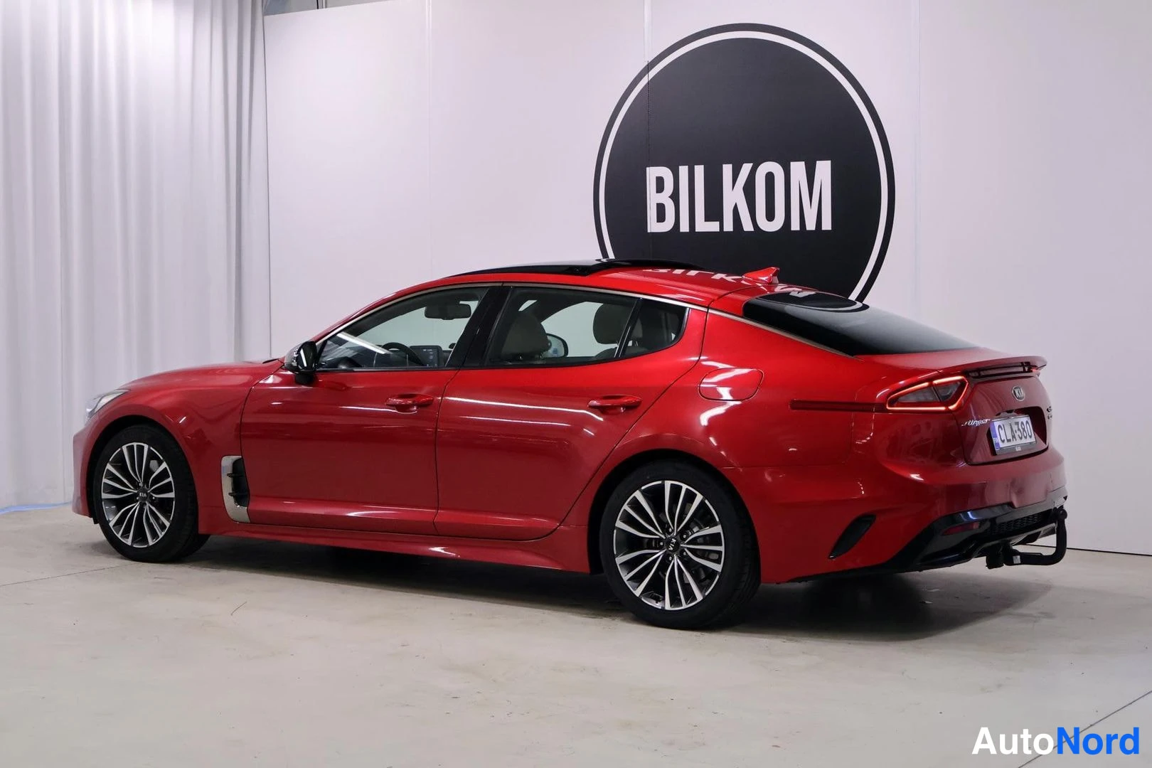 Takaviisto: Punainen Kia Stinger -henkilöauto takakulmasta, näkyvissä kattoluukku ja vetokoulu.