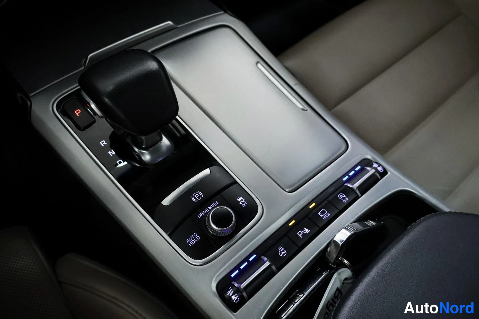 Etuistuimet: Centre console featuring automatic gear selector marked P-R-N-D, Drive Mode controller, Auto Hold function button, parking assist toggle, electronic parking bra