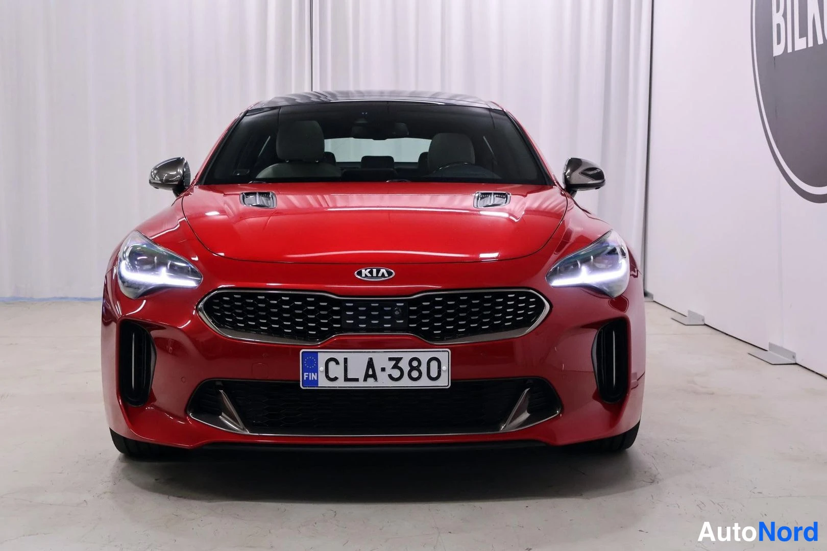 Edestä: Red Kia Stinger direct frontal view with license plate