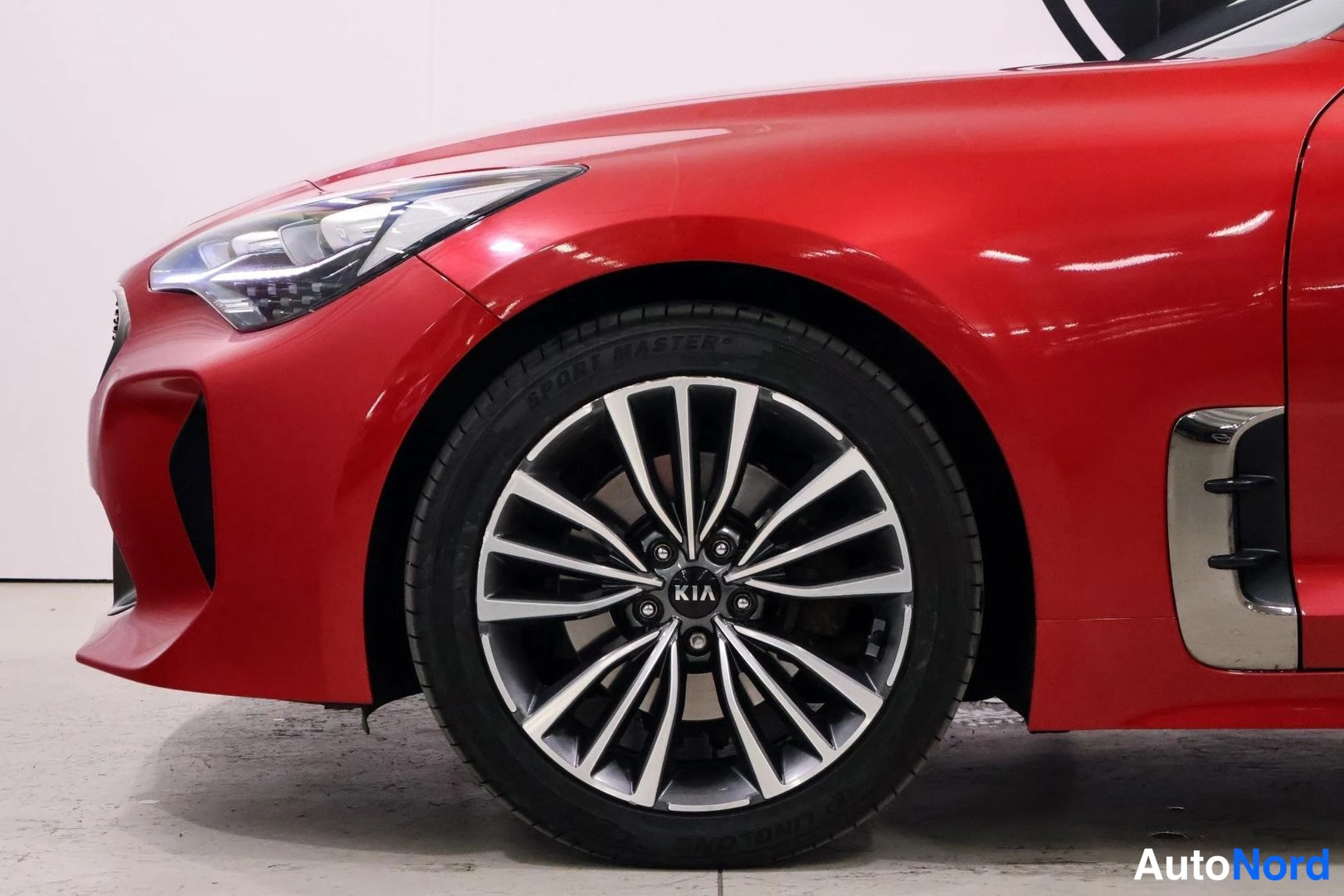 Yksityiskohta: Close-up of red front wheel assembly with two-tone alloy rim