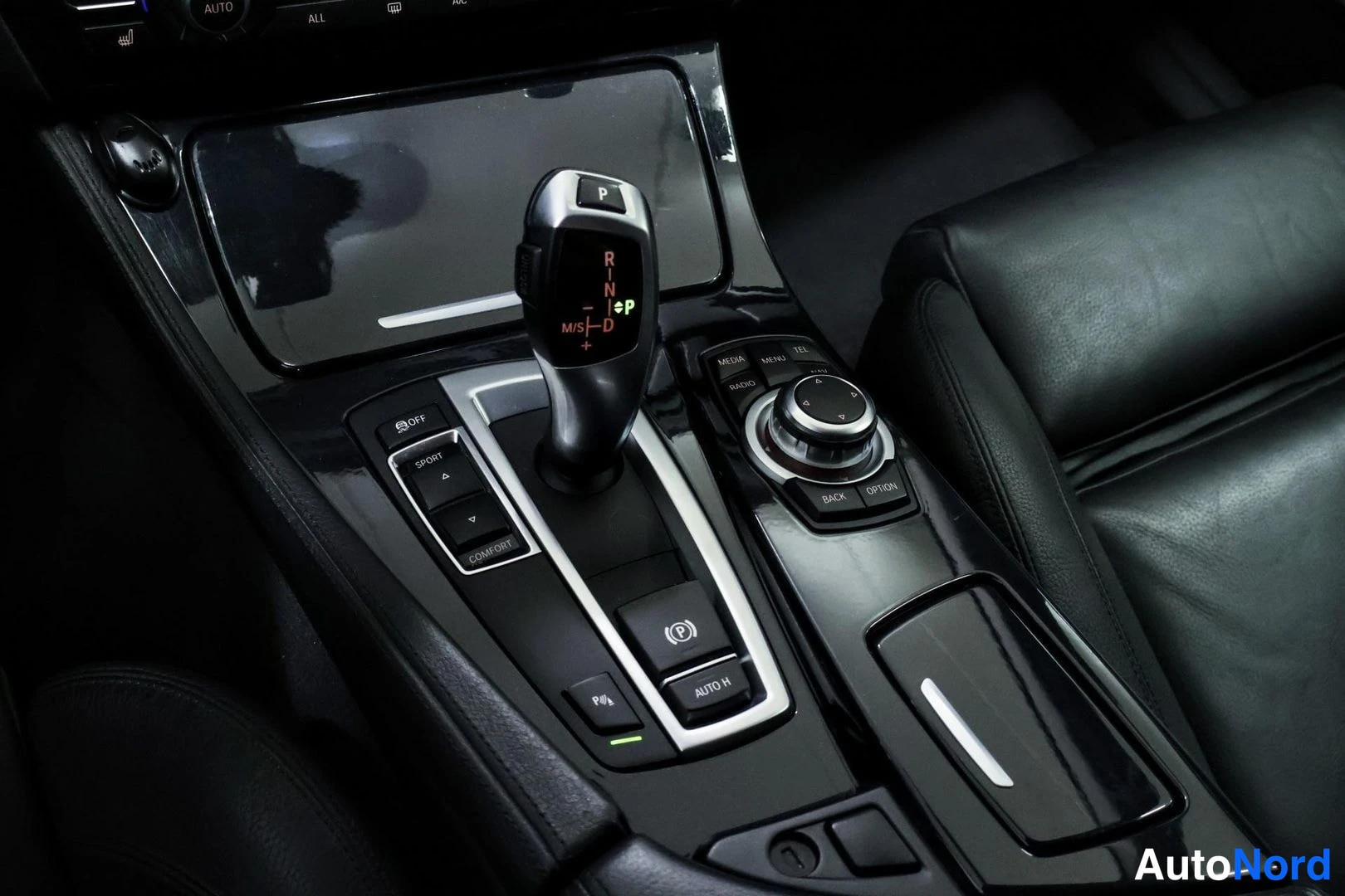 Muu: Vaihteenvalitsimen kohdalla näkyy P,R,N,D-merkinnät sekä napit Sport ja Comfort, elektroninen parkkitesti.