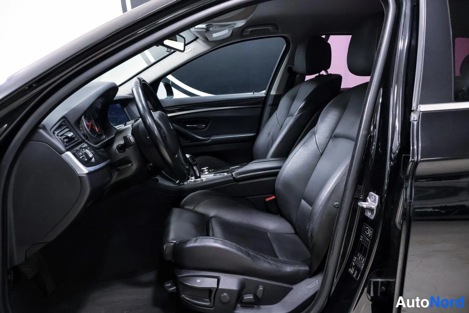 Etuistuimet: Black leather front passenger seat with visible power adjustment controls on the side and lower front bolster.