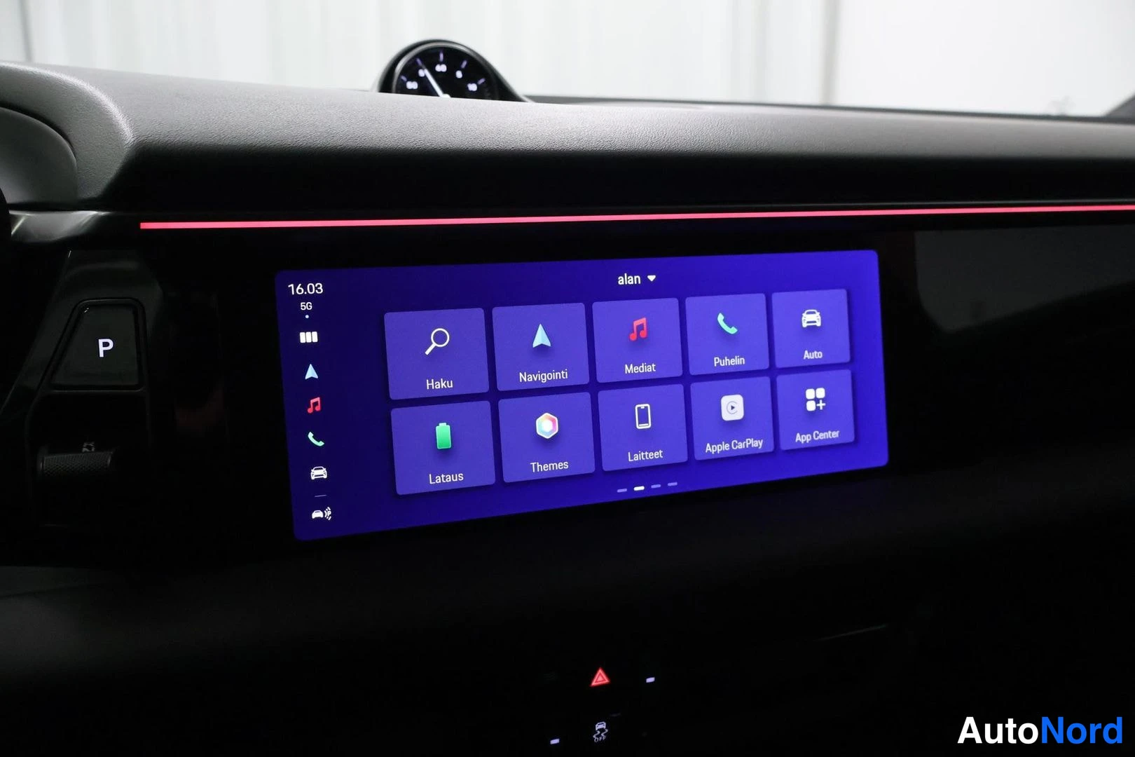 Yksityiskohta: Infotainment-näytön päävalikko: Haku, Navigointi, Mediat, Puhelin, Auto, Lataus, Themes, Laitteet, Apple CarPlay ja App Center.
