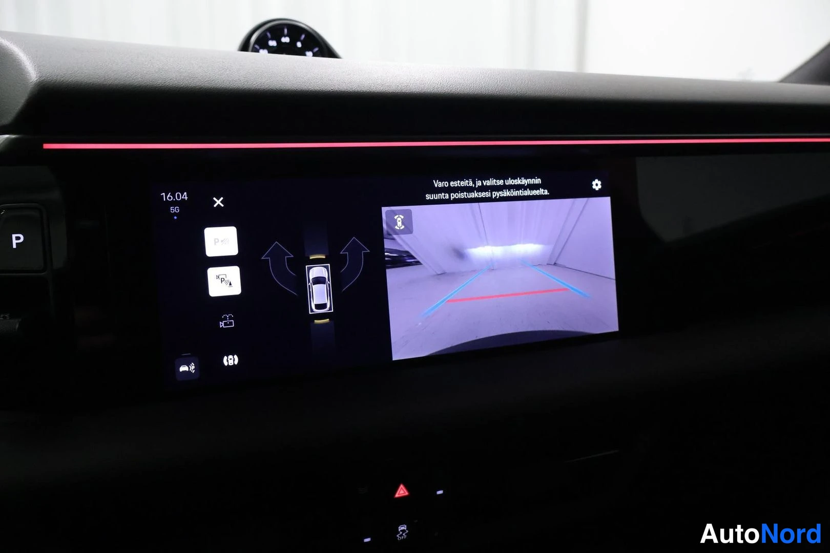 Ohjaamo: Porsche Macanin mittariston keskusnäyttö näyttää takakaamera-äkuvaa, pysäköintituen graafista esitystä ja ajoneuvon valintapainikkeita.