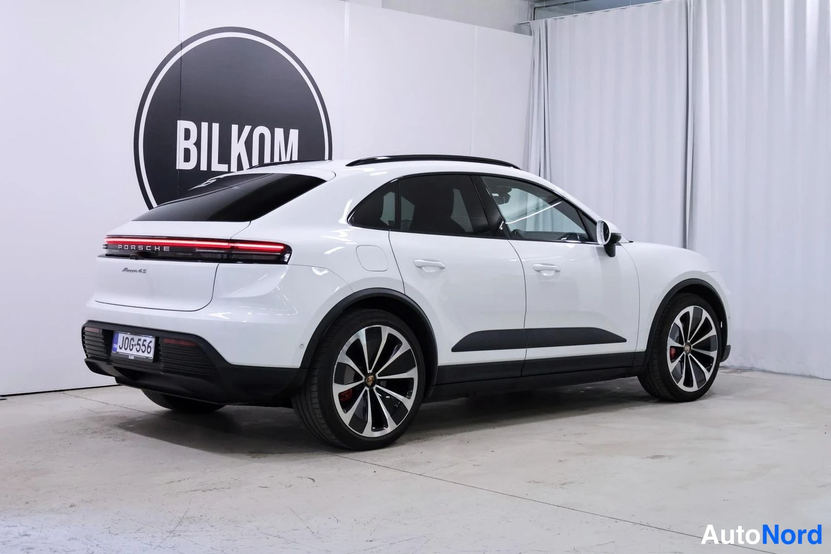 Takaviisto: Reaksiotakaiskulma kuvassa näkyvä valkoinen Porsche Macan, jossa on kattojen raide ja mustat alaosat.