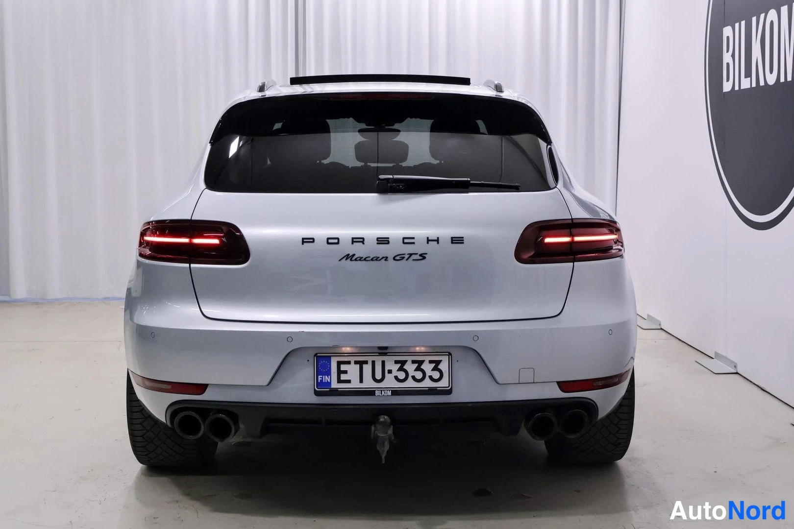 Takaa: Hopeanvärinen Porsche Macan GTS takaa valokuvattuna studiossa, rekisteritunnus, kattoluukku auki asennossa.
