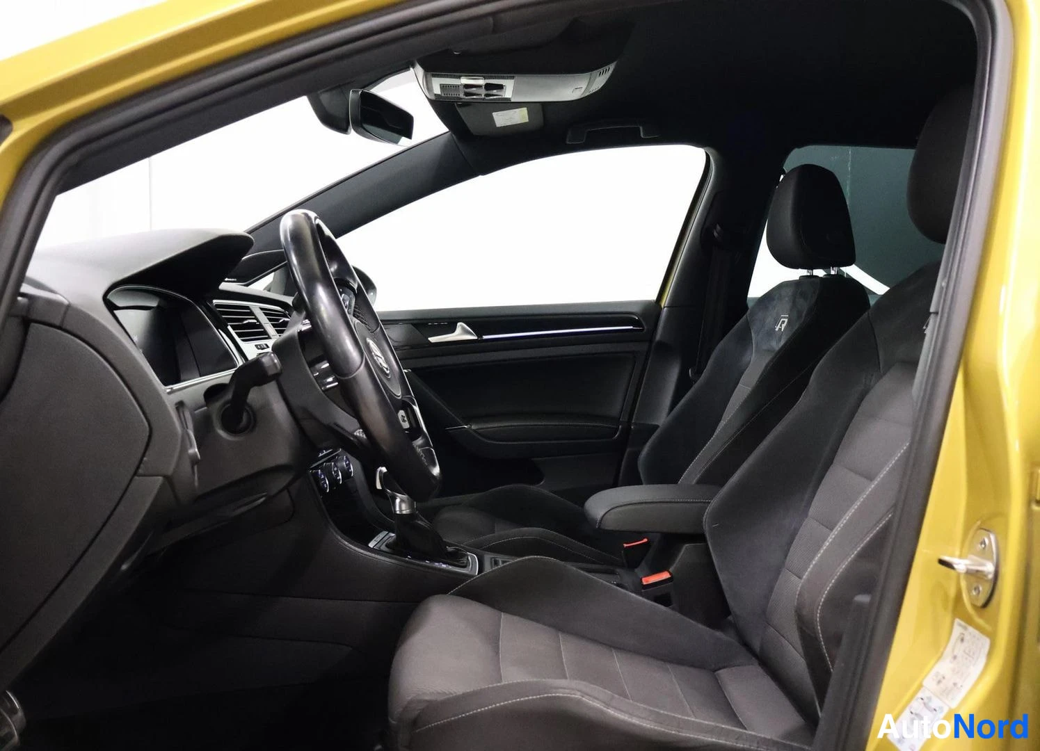 Etuistuimet: Interior shot showing front driver and passenger seats with multifunction steering wheel. Black interior with door panel visible.