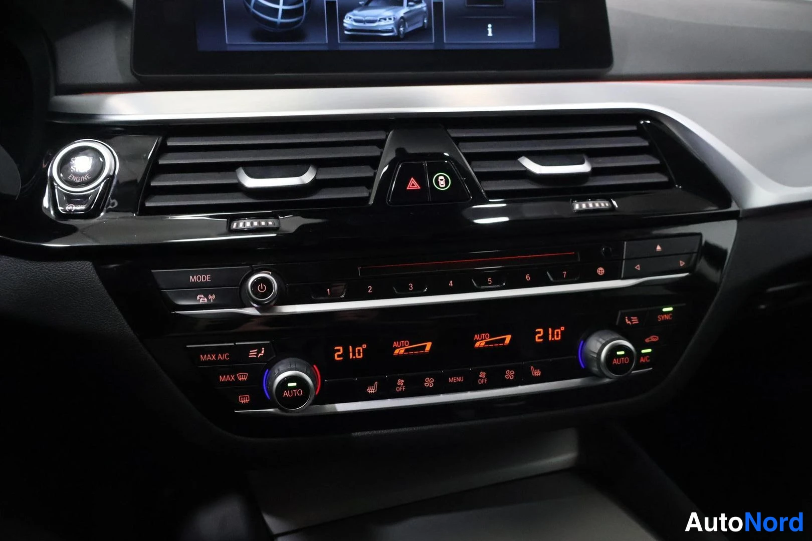 Muu: Automaton dashboard center console with climate controls and infotainment screen bottom edge.