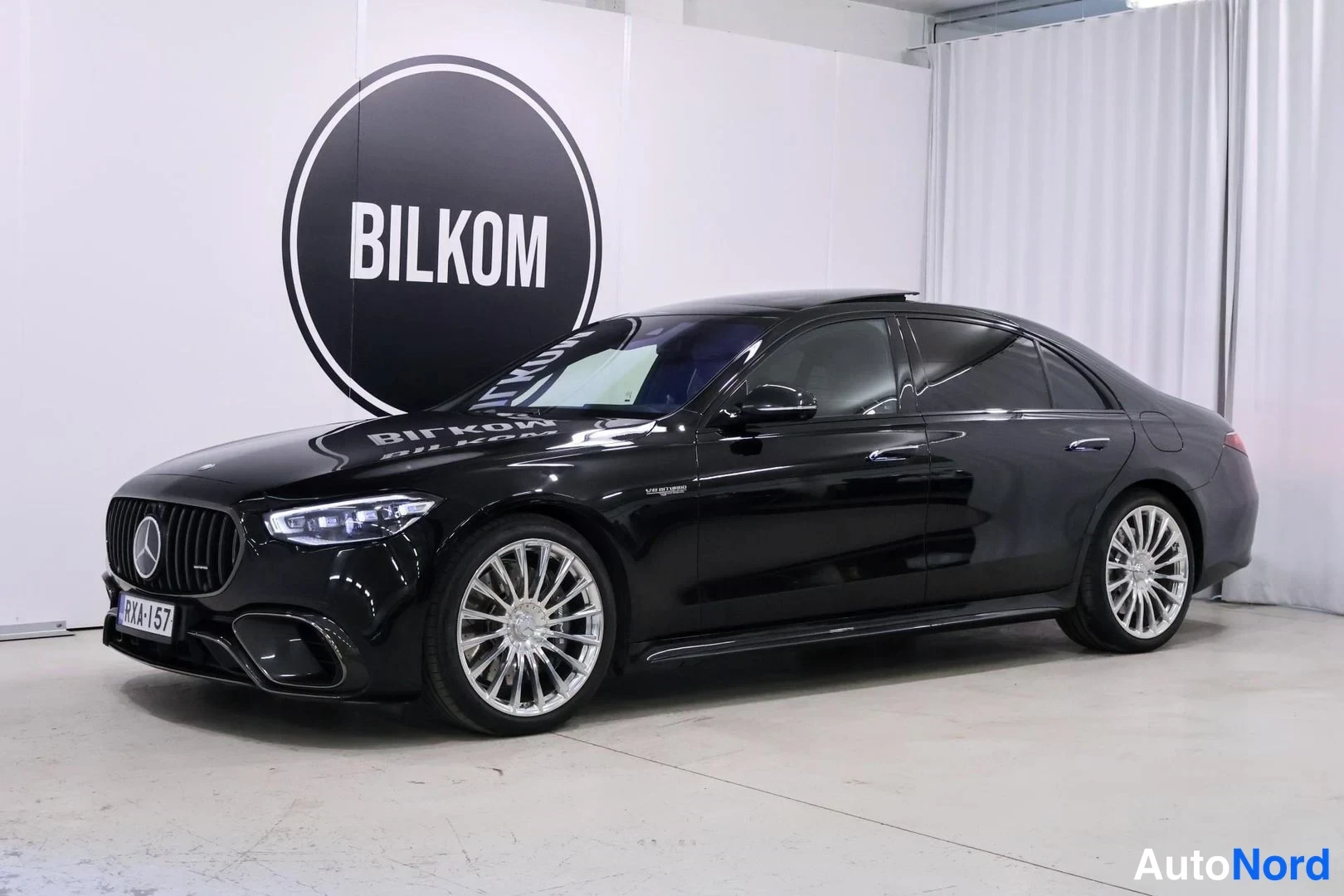 Etuviisto, nokka vasemmalle: Musta Mercedes-Benz S 63 AMG -sedan kuvattu kolmivartalokulmasta edestä vasemmalla sisätiloissa.