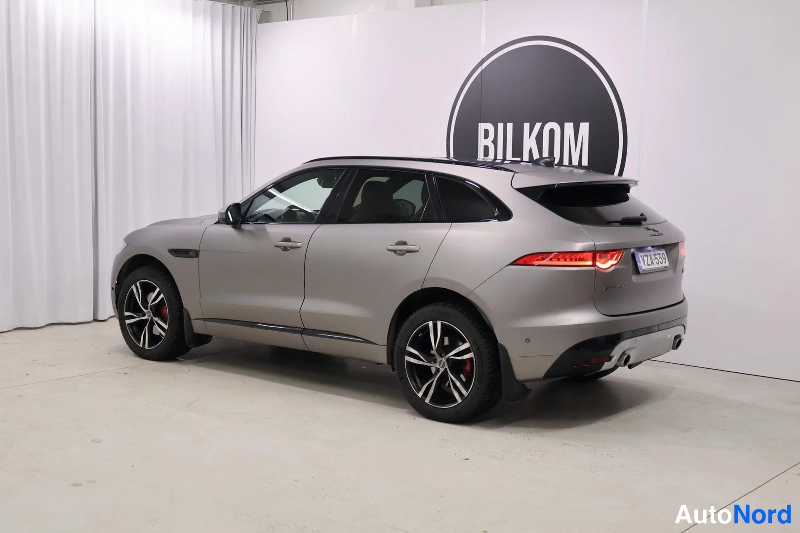 Takaviisto: Hopeanharmaa SUV takaa-seitsemältä kuvattuna studiossa