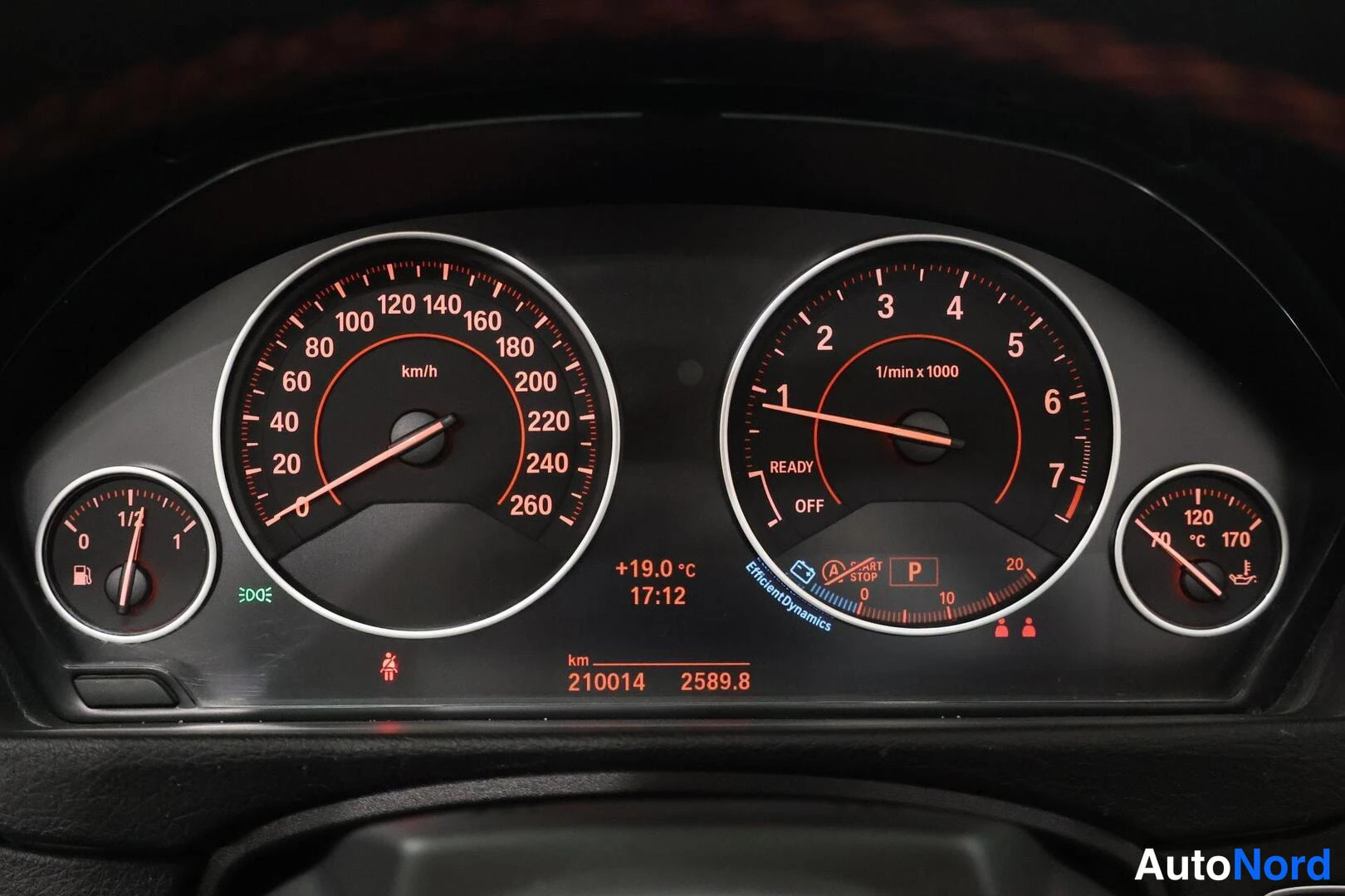 Yksityiskohta: Kojelaudan mittaristo punaisella valaistuksella: nopeusmittari 260 km/h, kierroslukumittari, polttoaine- ja lämpötilamittarit, kilometrilukema 210014.