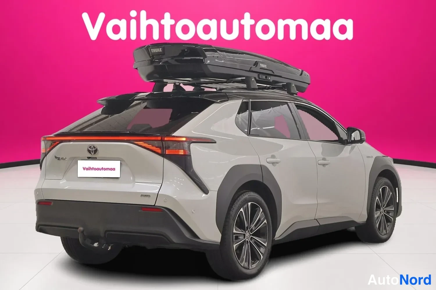 Takaviisto: Auton takaosa ja oikea sivu kolmen neljäsosan kulmasta; musta Thule-kattoboksi ja takavalojen poikittaispalkki näkyvissä.