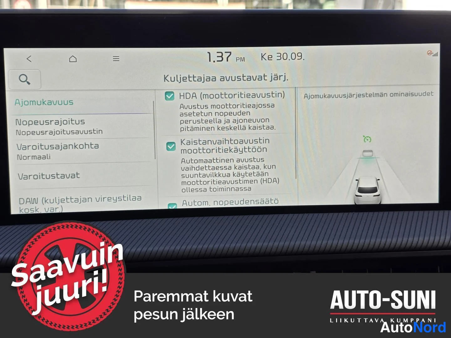 Muu: Auton infotainment-näytön kuva: asetusvalikko 'Kuljettajaa avustavat järj.', jossa valittuina HDA (moottoritieavustin), kaistanvaihtoavustin moottoritiekäytössä