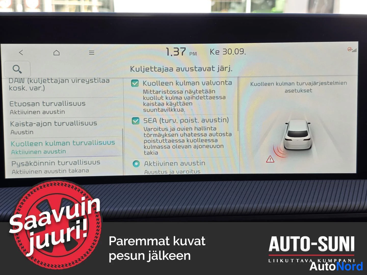 Muu: Auton kojelaudan infotainment-näyttö, jossa on näkyvissä kuljettajaa avustavien järjestelmien asetussivu suomeksi.