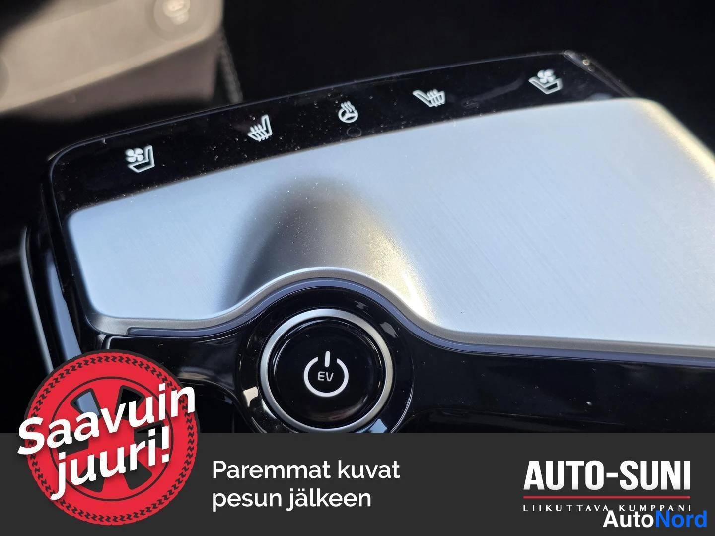 Muu: Auton keskuspaneelin 'EV'-painike ja lämmitysmerkinnät sisältävä paneeli lähikuvana.
