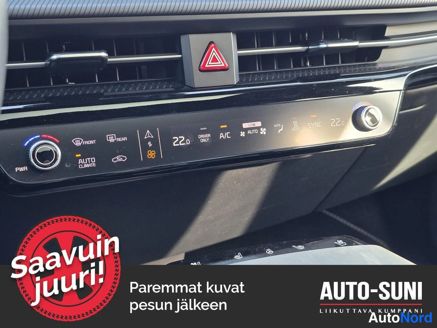 Muu: Kojelaudan ilmastointipaneeli lähikuva: kaksi säätöratasta, taustapeilin lämmitys, AUTO CLIMATE, A/C, SYNC ja 22 asteen asetukset.