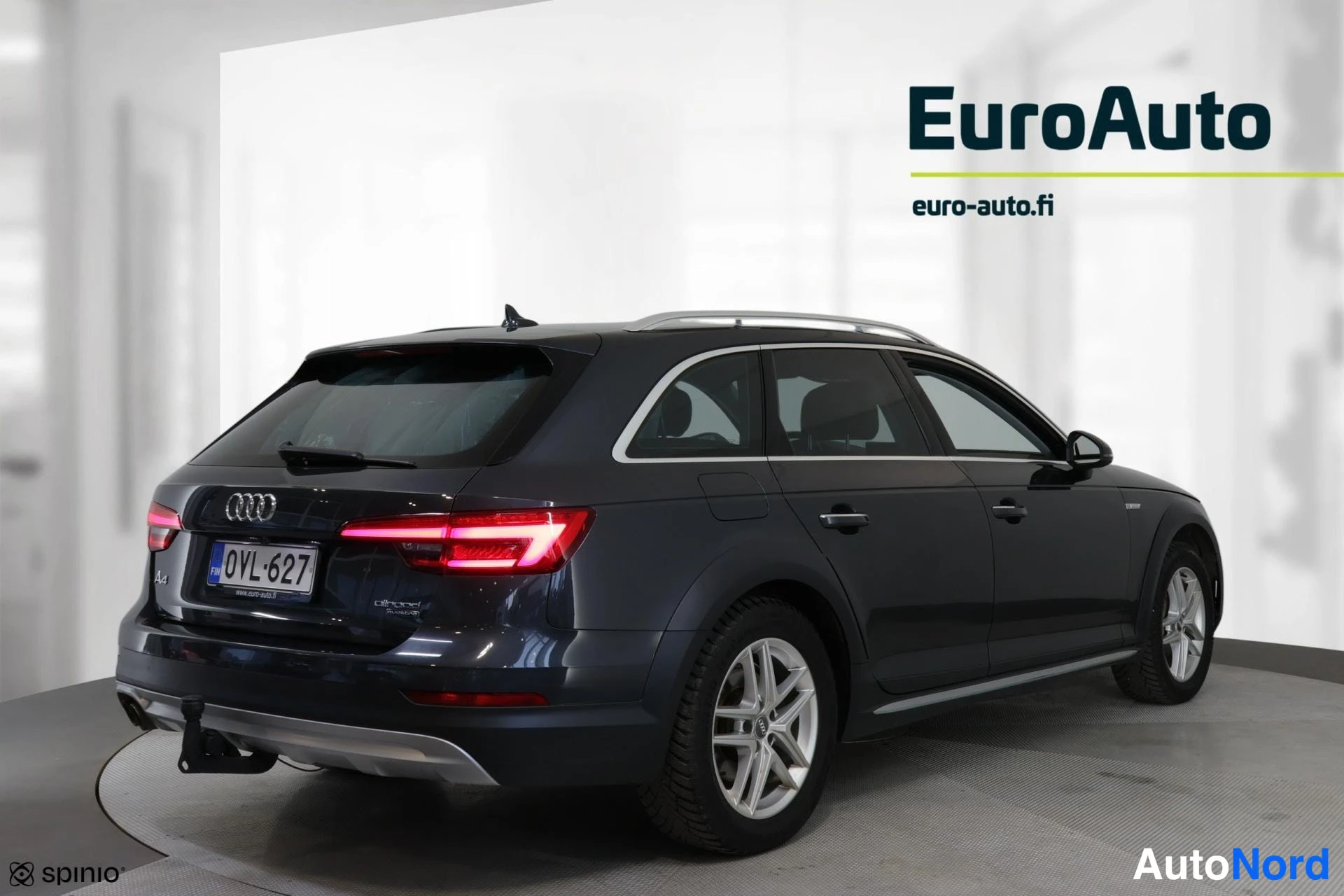 Takaviisto: Dunkler Audi A4 allroad im Studio mit silbernen Felgen und einem Anhängerkupplung am Heck.